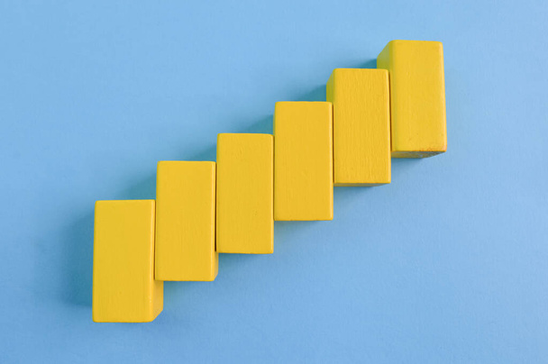 Желтый деревянный куб блоки изолированы на голубом фоне - Фото, изображение