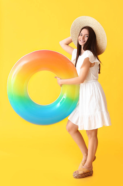 Mujer joven con anillo inflable sobre fondo de color - Foto, imagen