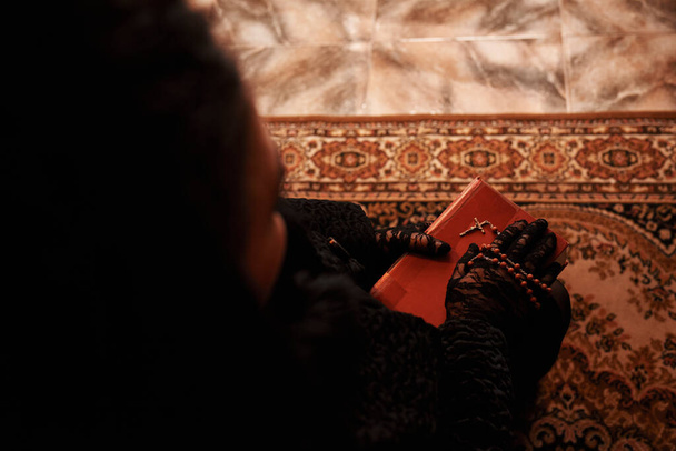 Un rosario y una biblia en las manos de una mujer con un velo negro - Foto, Imagen