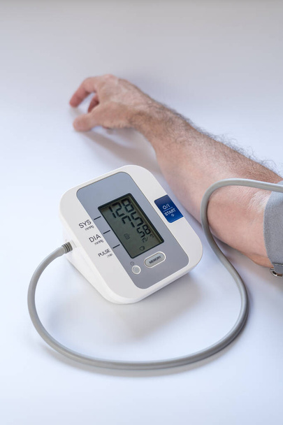 Man taking blood pressure with result of high blood pressure. - Photo, Image