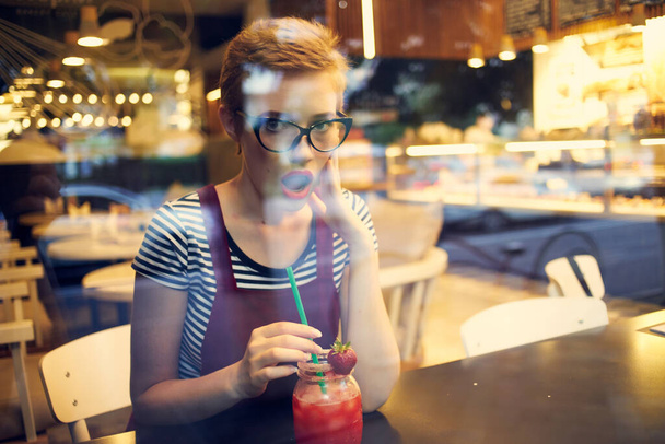 woman with short hair sitting at a table in a cafe cocktail drink loneliness - Photo, Image