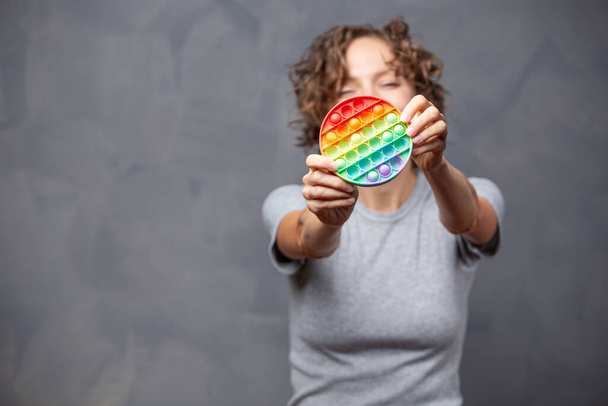  new sensory toy in woman hand - rainbow pop it with. Antistress toy for children and adult - Foto, Imagem