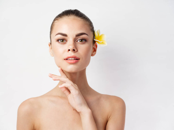 pretty woman naked shoulders attractive look yellow flower in hair cropped view - Photo, Image
