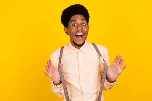 Photo of funky crazy cheerful african guy playful mood wear suspenders shirt isolated yellow color background - Foto, immagini