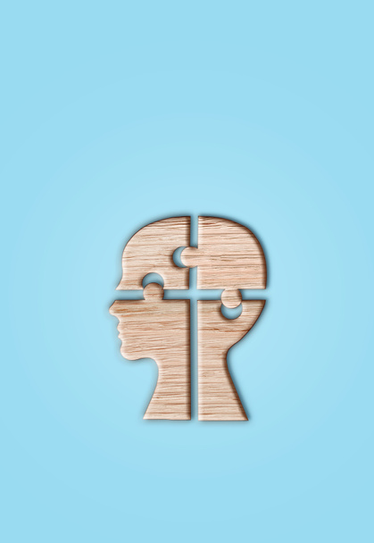 人間の頭のシルエット、青い背景にカットされたジグソーピース、精神的な健康のシンボル. - 写真・画像