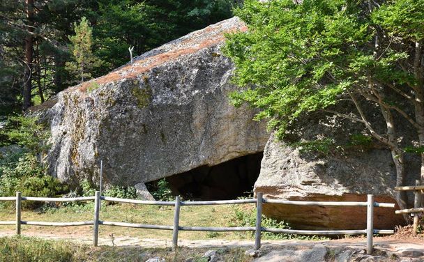 Große Felshöhle am Eingang zur Schwarzen Lagune. Kopfsteinpflasterstraße mit Holzgeländer, Provinz Soria, Spanien. - Foto, Bild