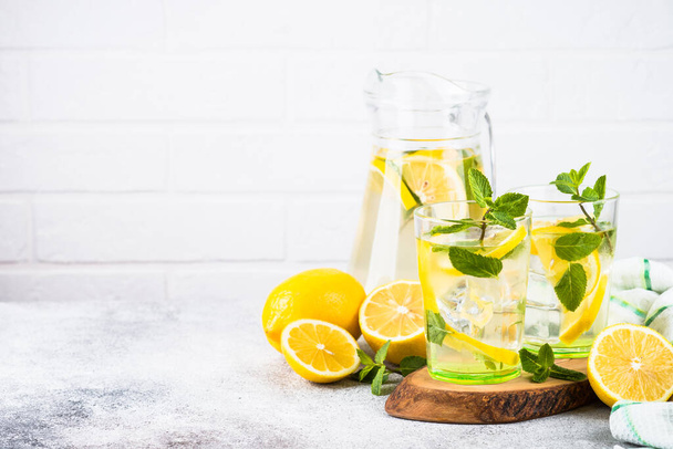 Lemonade in two glasses at white table. - Zdjęcie, obraz
