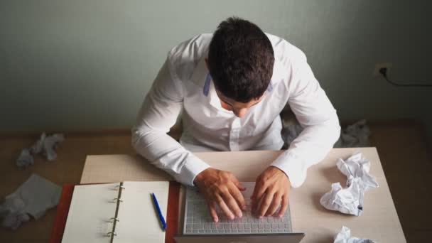 Šokovaný frustrovaný muž pracující na dálku doma pomocí notebooku. - Záběry, video