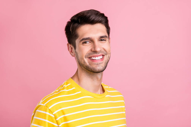 Фото молодого щасливого веселого чоловіка посміхається гарний настрій одягати жовті футболки ізольовані на рожевому кольорі
 - Фото, зображення