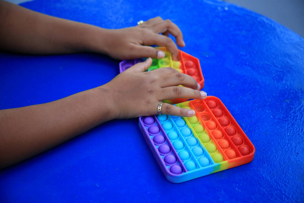 salvador, bahia, brazil - szeptember 1, 2021: gyermek kéz játszik Pop It Fidget Játékok Brin játék Salvador város. - Fotó, kép