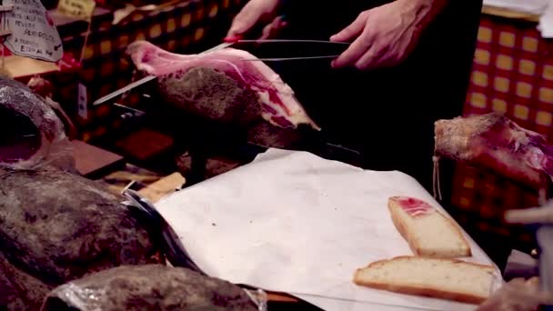 Σερβιτόρος ενώ τεμαχίζει το νόστιμο prosciutto crudo, τυπικό ιταλικό ζαμπόν - Πλάνα, βίντεο