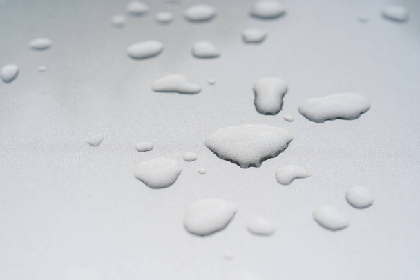 Drops of water or rain on a silvery surface. - Φωτογραφία, εικόνα