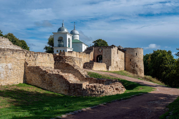Uitzicht op de muur van de vesting Izborsk, de Nikolskipoort en de kathedraal van Sint Nicolaas (Nikolsky) (XIV-XVII eeuw) op een zonnige zomerdag. Stary Izborsk, regio Pskov, Rusland - Foto, afbeelding