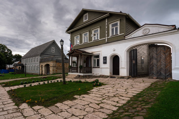 Vue des bâtiments historiques marchands des domaines sur la rue principale de la rue Izborsk Pechorskaya par une journée nuageuse d'été, Izborsk, région de Pskov, Russie - Photo, image