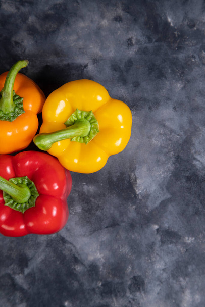 Colorful healthy bell peppers placed on a stone background . High quality photo - Fotó, kép