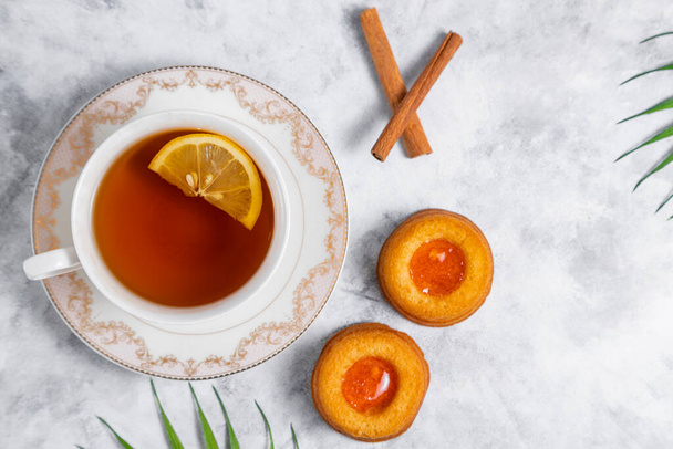 Šálek čaje s domácími koláčky s meruňkovým džemem. Kvalitní fotografie - Fotografie, Obrázek