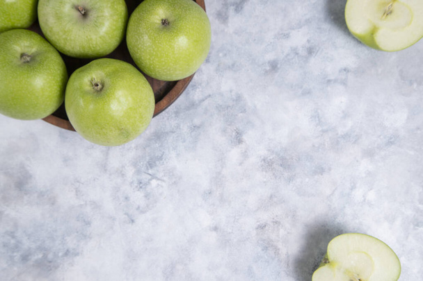 Placa de madera de frutos de manzana verdes maduros enteros y cortados en rodajas. Foto de alta calidad - Foto, imagen