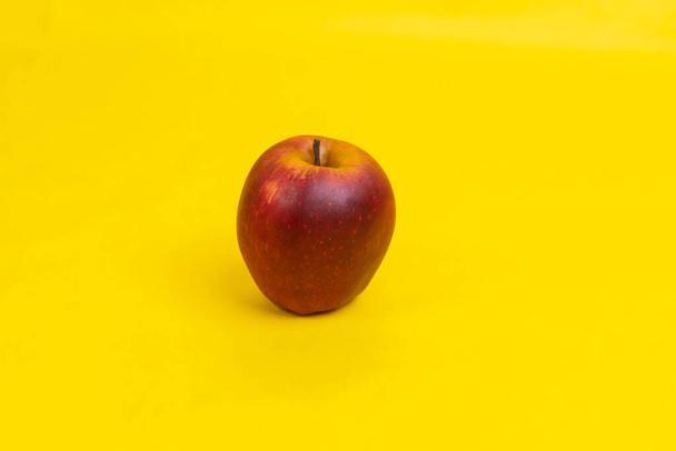 A red apple on a yellow background - 写真・画像