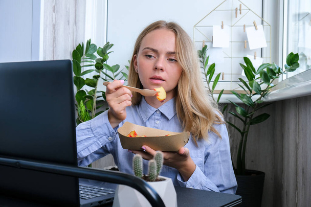 Woman holding lunch zero waste box, food delivery box with healthy meal weight loss diet menu, vegan food at workplace in office. Office employee having vegan lunch at workspace - Photo, Image