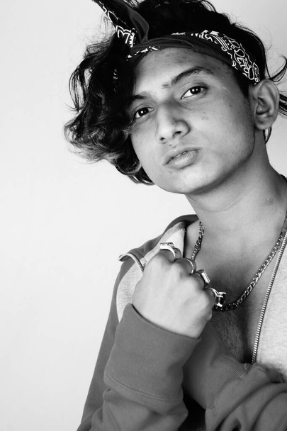 A grayscale of an Indian hipster guy with a headband posing to the camera - Foto, Imagen