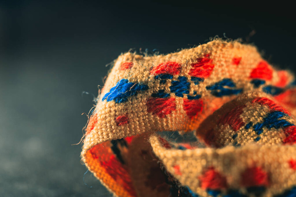 A selective focus shot of a colorful textile ribbon with traditional pattern - Foto, Bild