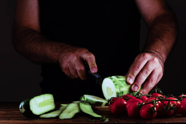 The man hands cutting vegetables - Фото, изображение