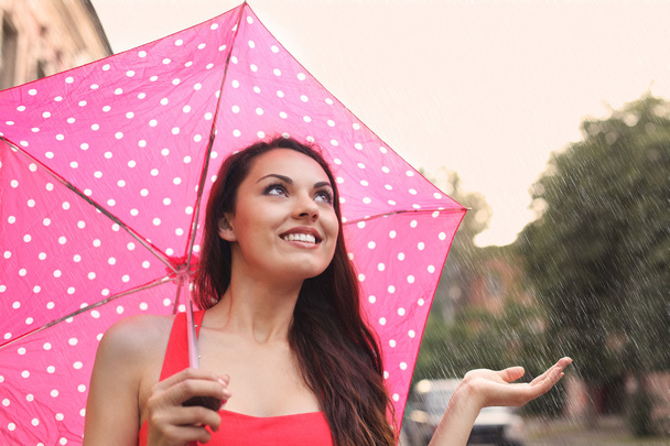Porträt eines schönen jungen Mädchens, das mit Regenschirm geht  - Foto, Bild