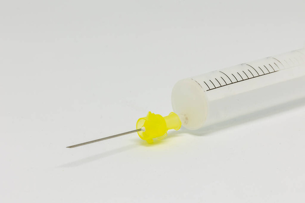 A closeup of a syringe on a white table. - Foto, Imagen