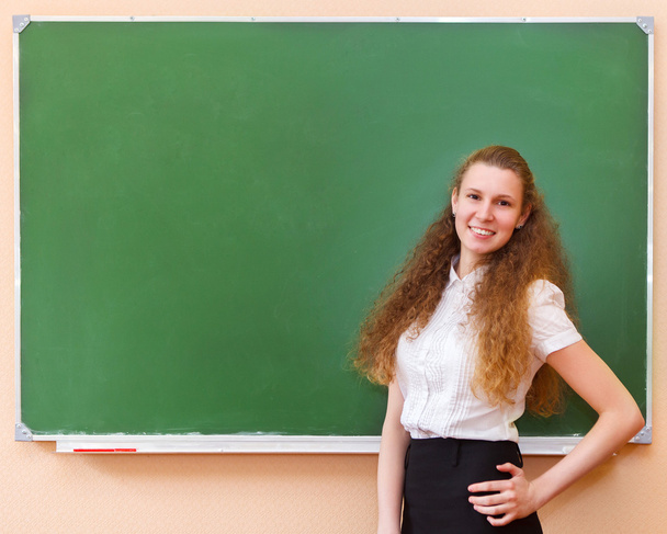 φοιτητής κορίτσι στέκεται κοντά σε μαυροπίνακα  - Φωτογραφία, εικόνα