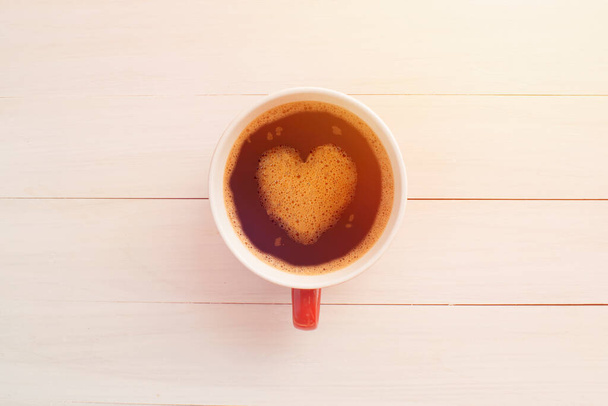 Cup of coffee on white wooden desk shape of heart. - Photo, Image
