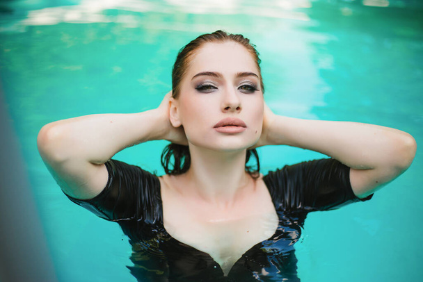 Donna di aspetto modello nuota in vacanza in una piscina all'aperto - Foto, immagini