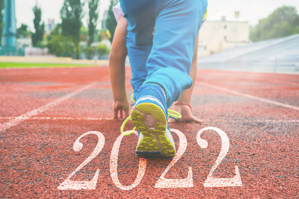 close-up of legs in sneakers at the start. Beginning and beginning of the new 2022, goals and plans for the next year - Foto, afbeelding