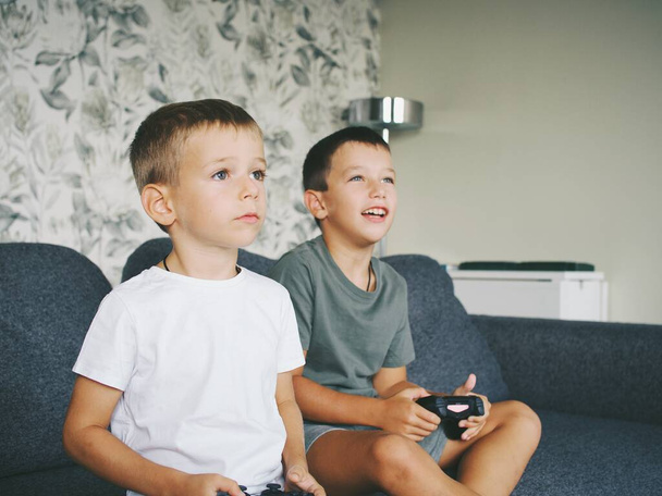children play computer games joystick console on TV - Foto, afbeelding