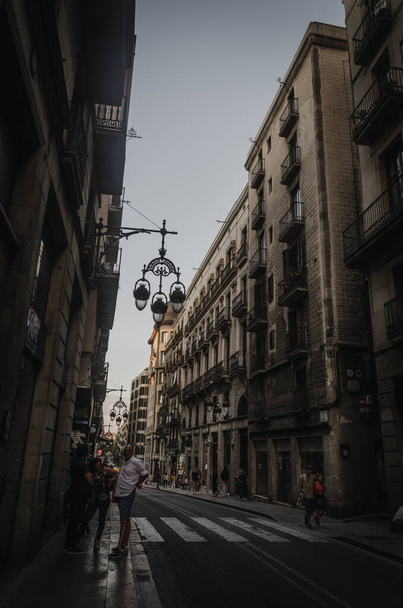 BARCELONA, SPAIN - Jul 25, 2021: A vertical shot of an old street in Barcelona, Spain, and people walking there - Photo, image