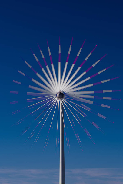 A vertical shot of a windmill against a clear blue sky - Фото, изображение