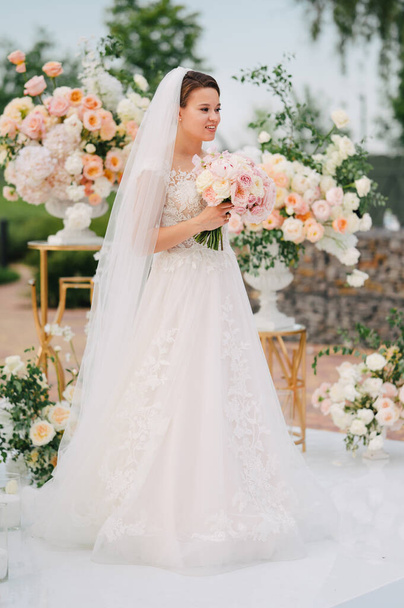 bride in the wedding ceremony area of live white and pink flowers.  - Foto, Imagen