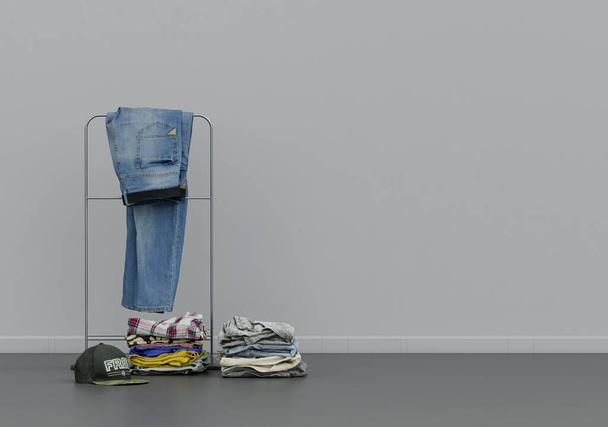 A jeans on a hanger with a hat and folded clothes, cloth and accessories in a grey interior room with copy space, 3d Rendering, nobody - Fotoğraf, Görsel