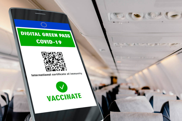 Pase verde digital de la Unión Europea con el código QR en una pantalla móvil, fondo interior de un avión. Inmunidad de Covid-19. Viaje sin restricciones. - Foto, Imagen