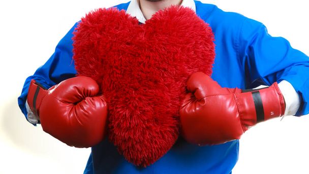 Guy ready to fight for love. Adult man wearing red boxing sporty gloves holding heart shape. Winning with cardiology disease concept. - Фото, изображение