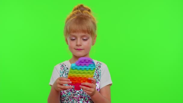 Κομψό χαριτωμένο μικρό παιδί παίζουν με μοντέρνα ποπ αυτό φούσκα squishy αισθητηριακό παιχνίδι παιχνίδι για chroma κλειδί - Πλάνα, βίντεο