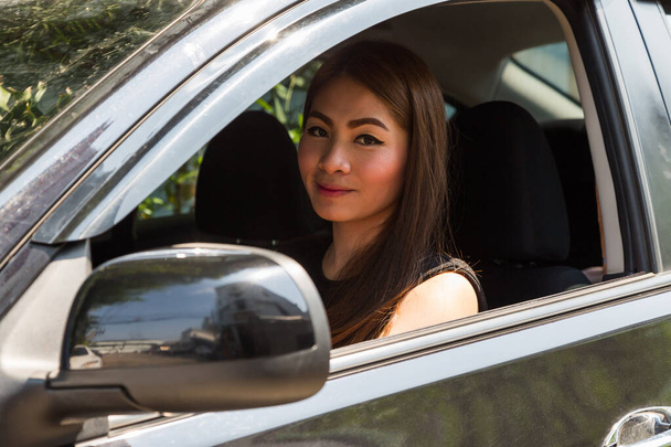 glimlachende vrouw zitten in auto achtergrond - Foto, afbeelding