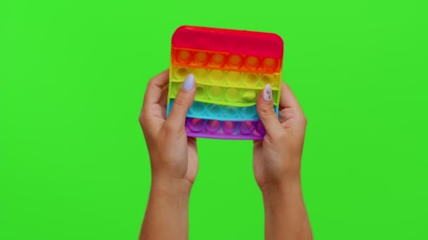 Krom anahtar arka planında izole edilmiş popüler yumuşak silikon kabarcıklar duyusal oyuncak oyunu oynayan eller - Video, Çekim