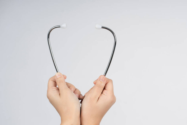 Medical background with hands holding a stethoscope. - Zdjęcie, obraz