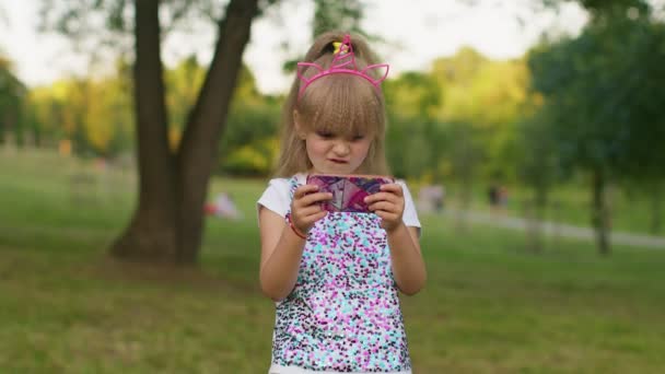 Παιδιά κορίτσι χάνει στο παιχνίδι κινητό τηλέφωνο, χρησιμοποιήστε squishy σιλικόνη αντι-στρες ποπ παιχνίδι για να ηρεμήσει - Πλάνα, βίντεο