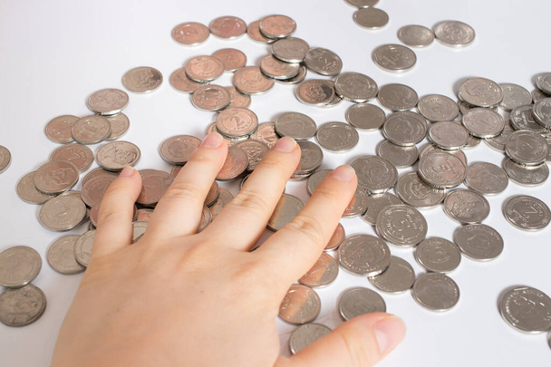 Oekraïense hryvnia, de munteenheid van Oekraïne. Man en munten hand close-up. Financiën, stijgende tarieven en een redelijke bijdrage van geld aan investeringen. - Foto, afbeelding
