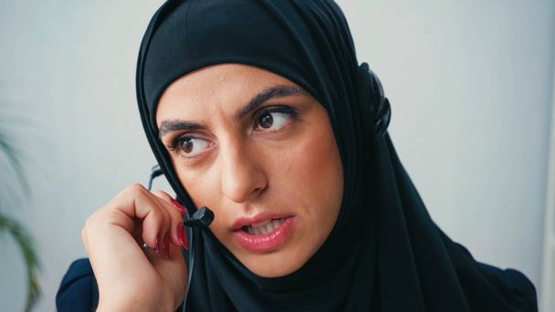 コールセンターでヘッドセットを使用してヒジャーブのイスラム教徒の女性  - 写真・画像