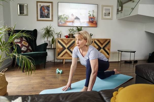 Ampla imagem da mulher idosa se exercitando em casa - Foto, Imagem