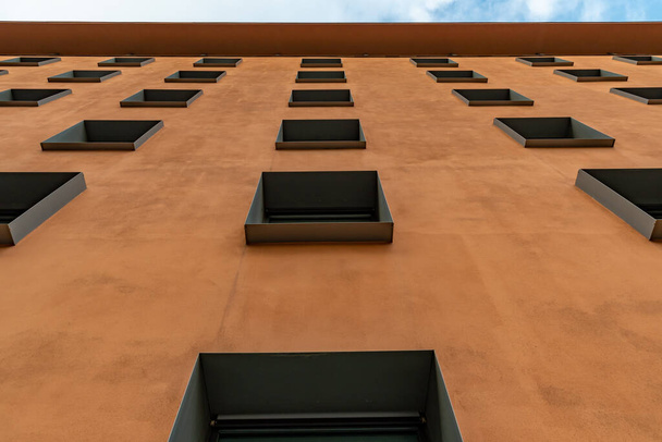 Геометрична міська структура коричневої стіни і ряди вікон в розмірній перспективі
 - Фото, зображення
