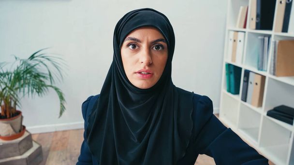 Muslimische Geschäftsfrau im Hidschab blickt in die Kamera  - Foto, Bild
