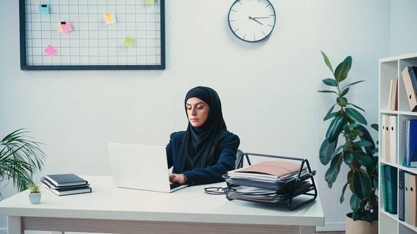 現代のオフィスでノートパソコンに入力するヒジャーブ州のイスラム教徒の実業家  - 写真・画像